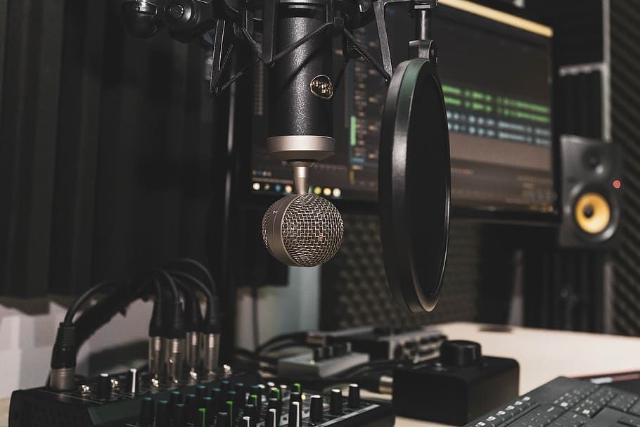 Professional recording studio setup with microphone, pop filter, and audio equipment.